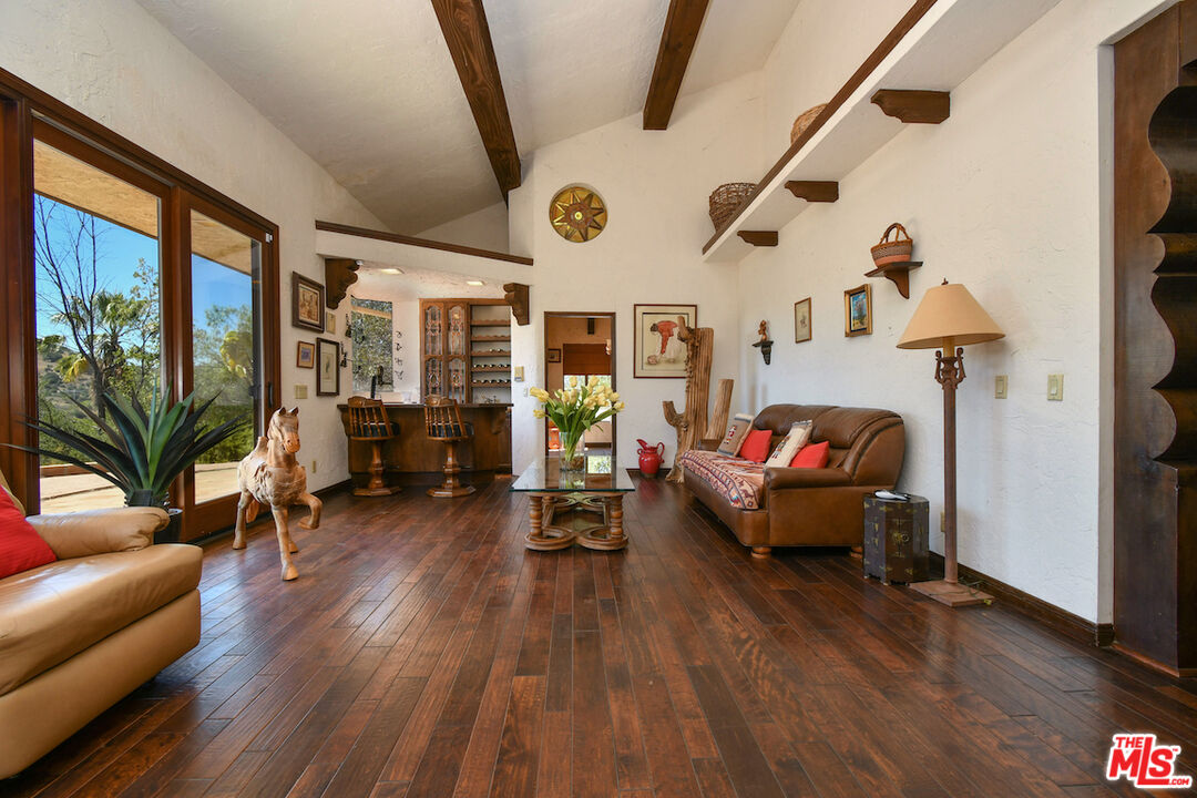 24926 Jim Bridger Road Hidden Hills, CA 91302 - Photo 3 of 40 a living room with furniture and wooden floor