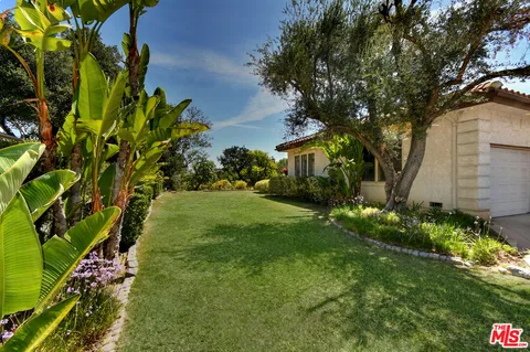a view of a house with backyard and sitting area