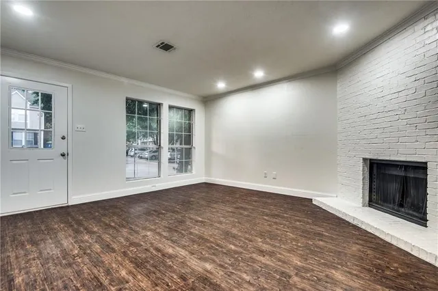 an empty room with windows and fireplace