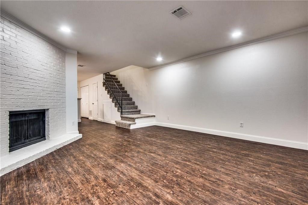35 Abbey Road Euless, TX 76039 - Photo 23 of 25 an empty room with wooden floor staircase and a fireplace