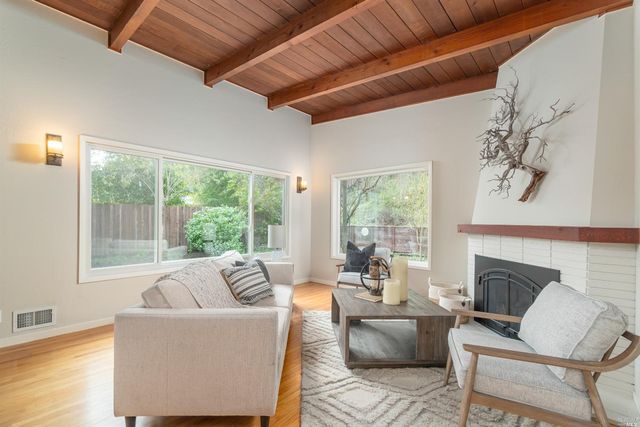 a living room with furniture a fireplace and a large window