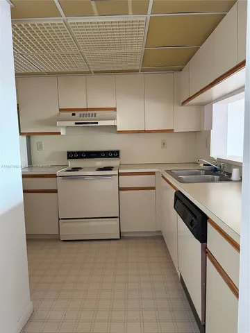 a kitchen with a stove sink and cabinets