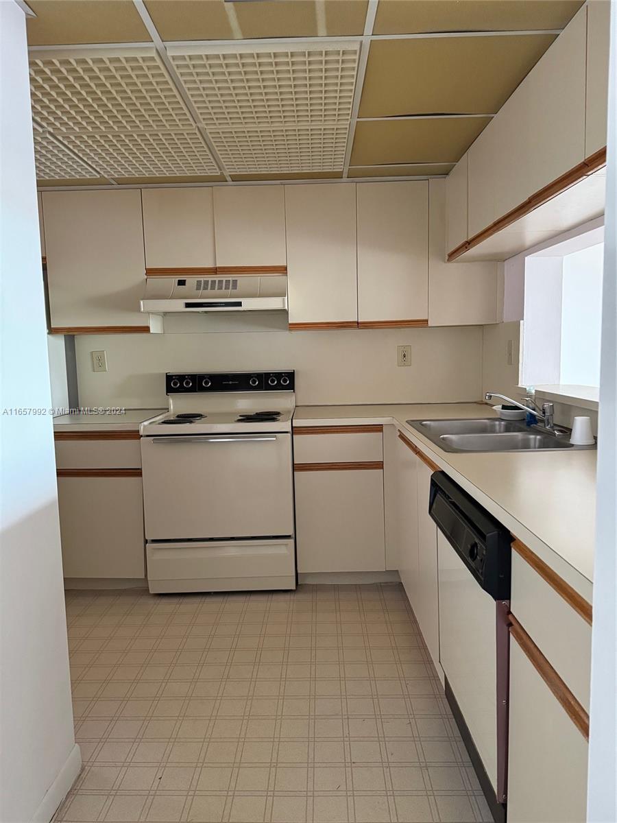 10253 Northwest 9th St Circle, Unit 4076 Miami, FL 33172 - Photo 5 of 11 a kitchen with a stove sink and cabinets