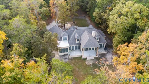 a aerial view of a house with a yard and large trees