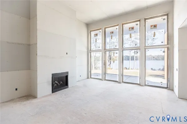 a view of an empty room with a fireplace and a window