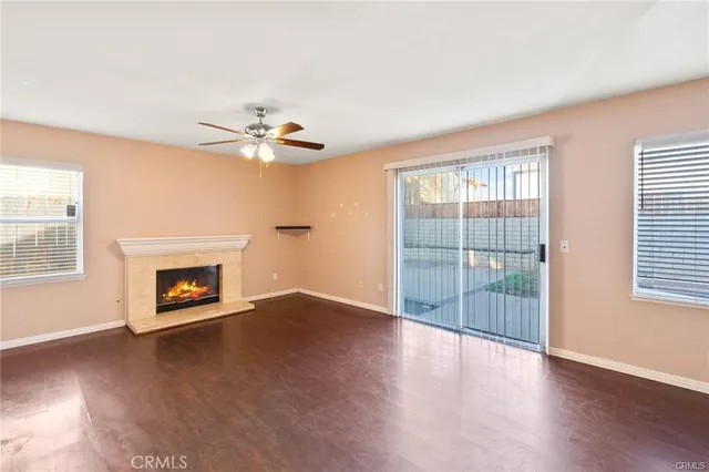an empty room with windows and fireplace