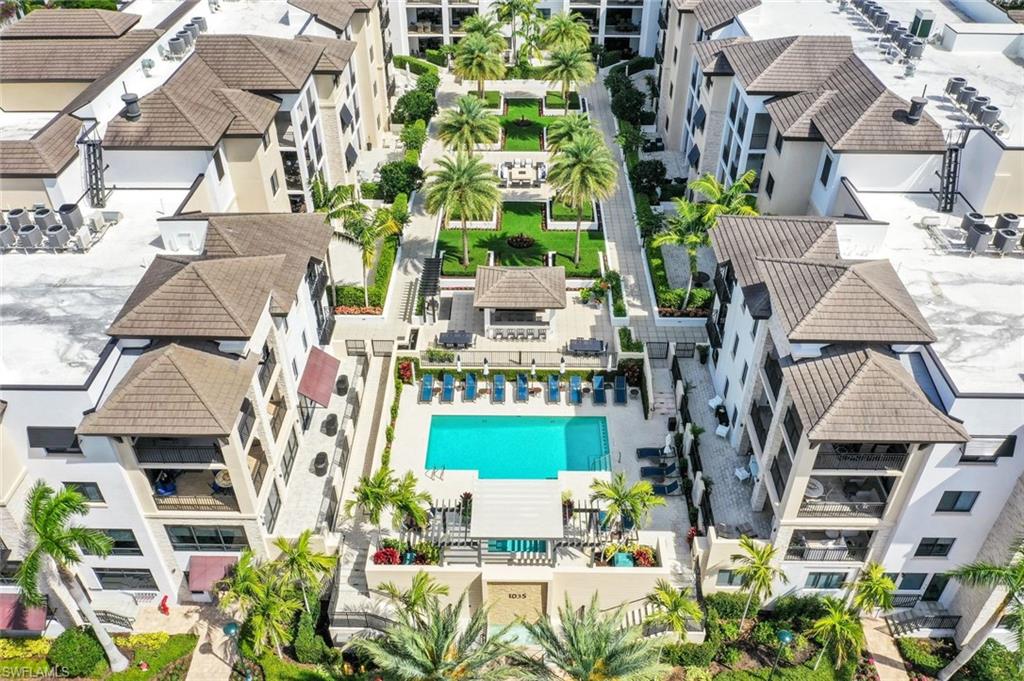 1035 3rd Avenue South, Unit 514 Naples, FL 34102 - Photo 28 of 35 an aerial view of a residential apartment building with a yard and potted plants