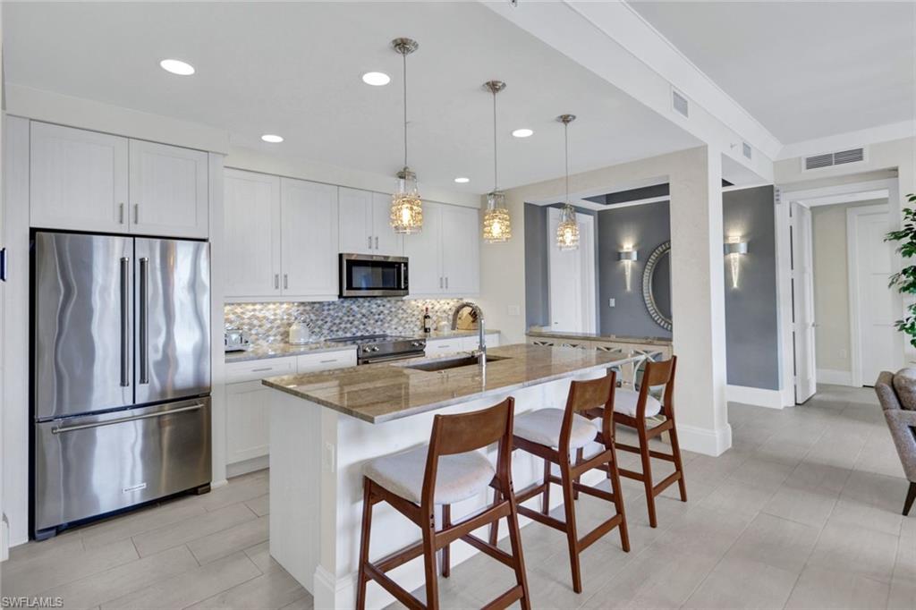 1035 3rd Avenue South, Unit 514 Naples, FL 34102 - Photo 6 of 35 a kitchen with stainless steel appliances granite countertop a sink a stove a refrigerator and island