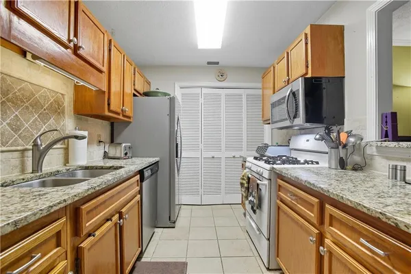 a kitchen with stainless steel appliances granite countertop a sink stove and refrigerator