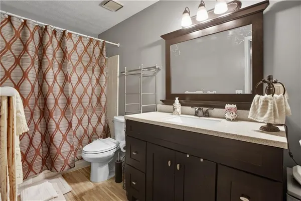 a bathroom with a granite countertop sink mirror vanity and toilet
