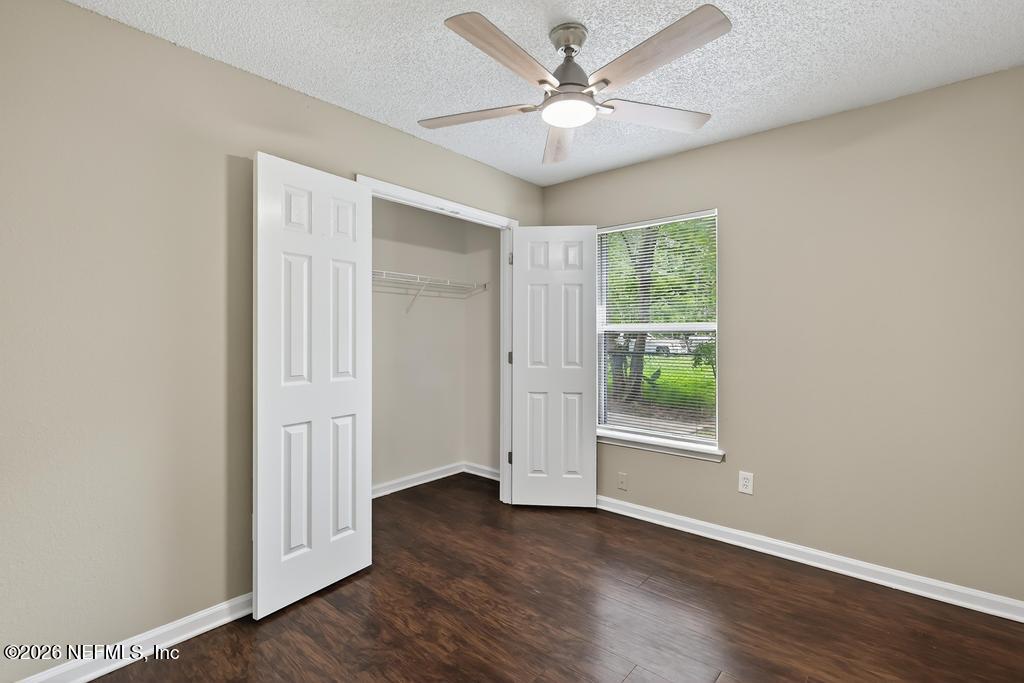 2080 Tuskegee Road Jacksonville, FL 32209 - Photo 13 of 23 an empty room with wooden floor fan and windows