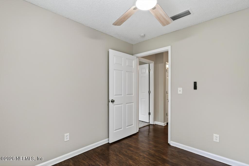 2080 Tuskegee Road Jacksonville, FL 32209 - Photo 14 of 23 an empty room with wooden floor and a ceiling fan