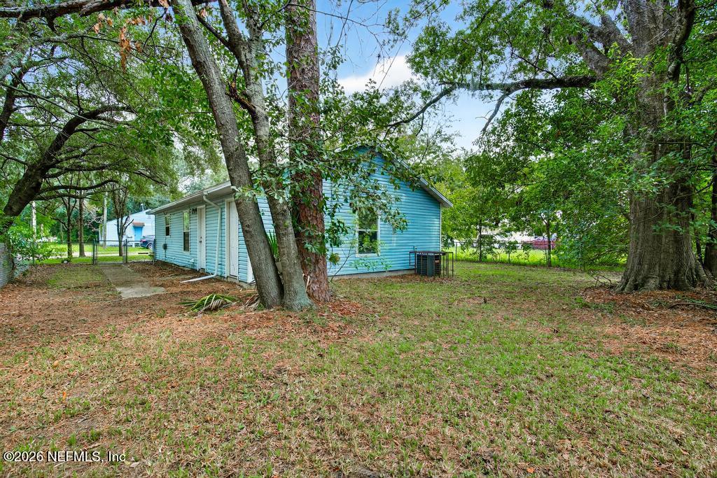 2080 Tuskegee Road Jacksonville, FL 32209 - Photo 21 of 23 a backyard of a house with plants and large tree