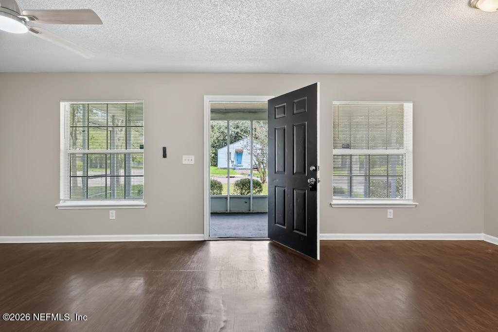 2080 Tuskegee Road Jacksonville, FL 32209 - Photo 4 of 23 an empty room with wooden floor and windows