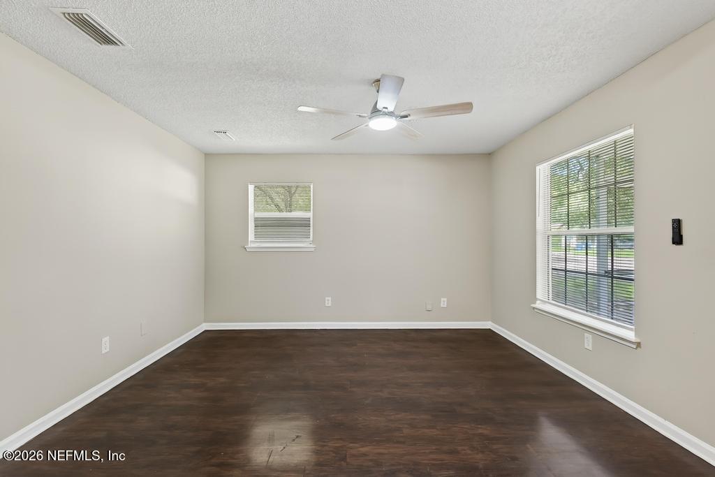 2080 Tuskegee Road Jacksonville, FL 32209 - Photo 5 of 23 an empty room with wooden floor and windows