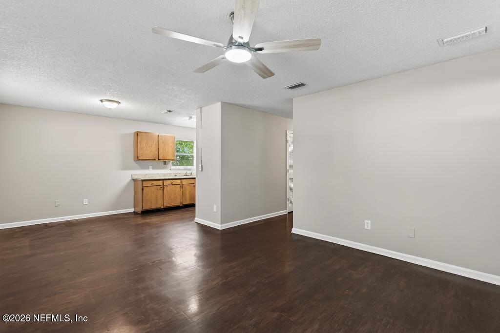 2080 Tuskegee Road Jacksonville, FL 32209 - Photo 8 of 23 a view of a kitchen with a sink a ceiling fan and a kitchen counter top space