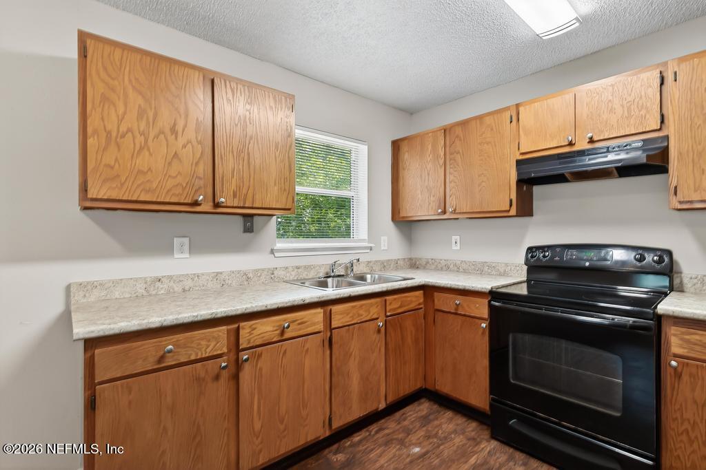 2080 Tuskegee Road Jacksonville, FL 32209 - Photo 10 of 23 a kitchen with stainless steel appliances granite countertop a sink a stove a microwave and cabinets