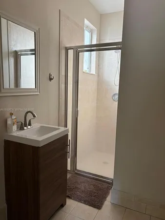 a bathroom with a glass shower door and sink