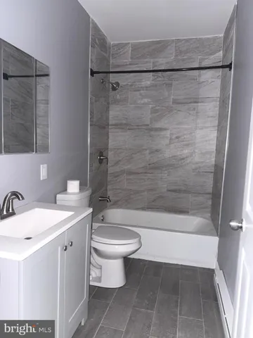 a bathroom with a bathtub shower sink vanity and toilet