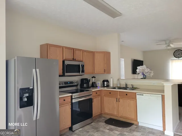 a kitchen with stainless steel appliances a refrigerator stove microwave and sink