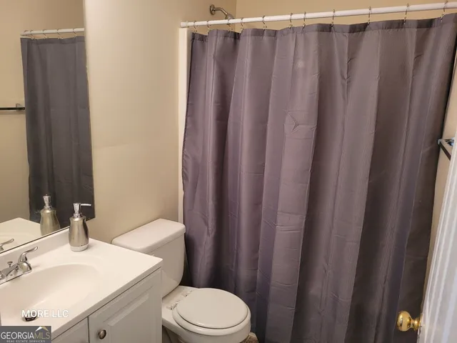 a bathroom with a sink a toilet a mirror