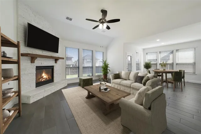 a living room with furniture a fireplace and a flat screen tv