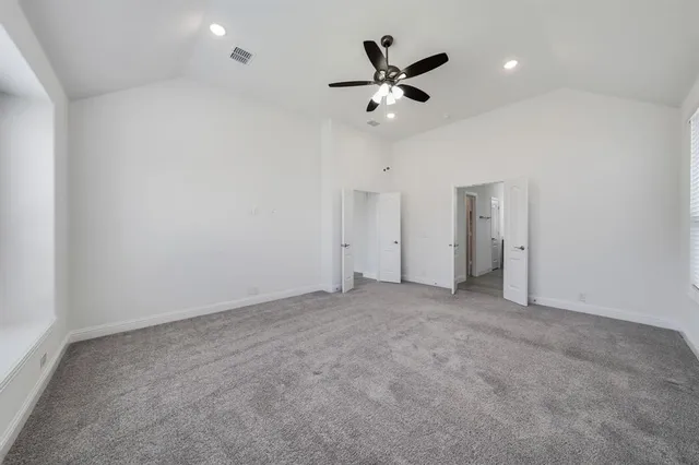 an empty room with a ceiling fan and a fan