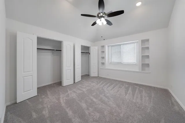 a view of an empty room with a ceiling fan