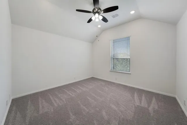 an empty room with a ceiling fan and a window