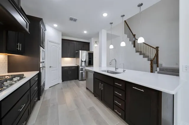 a large kitchen with a large counter top appliances and cabinets