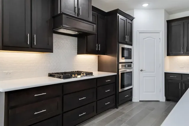 a kitchen with stainless steel appliances granite countertop a refrigerator and a stove