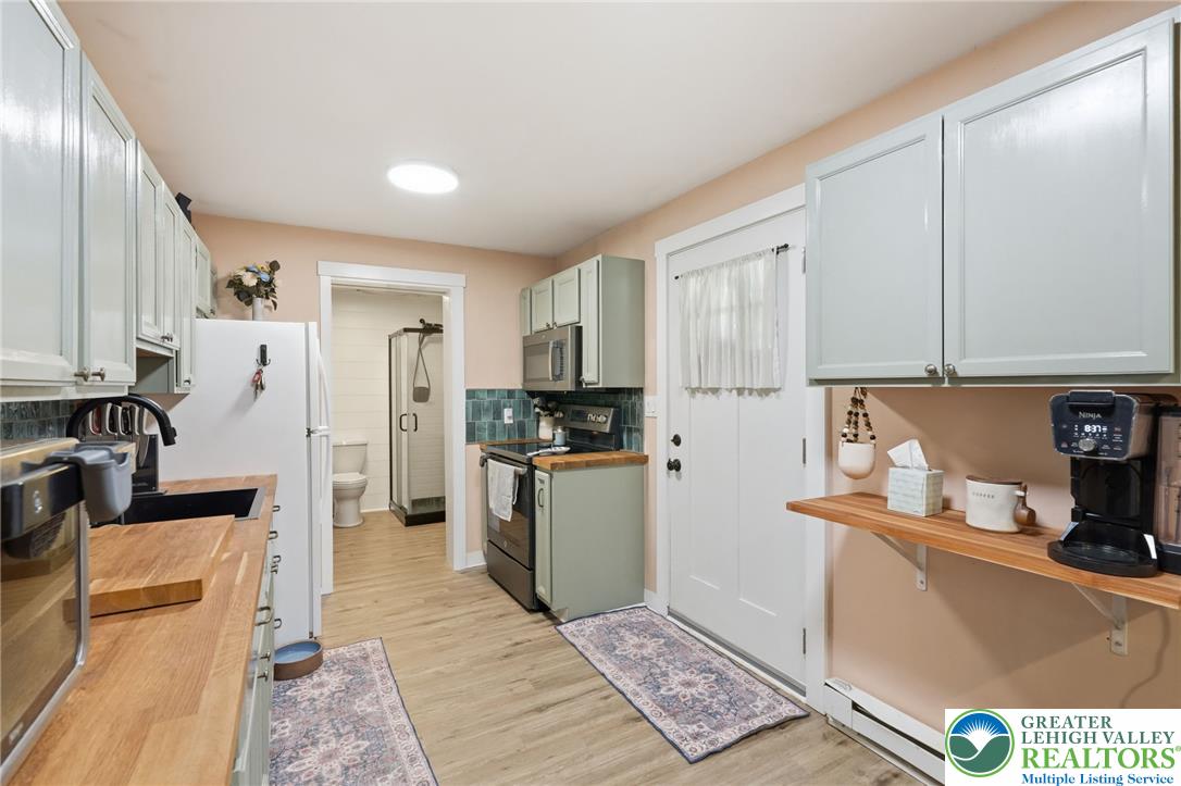 9033 Loop Road Slatington, PA 18080 - Photo 22 of 53 A compact kitchen with light wooden countertops and light-colored cabinetry maximizes functional living.