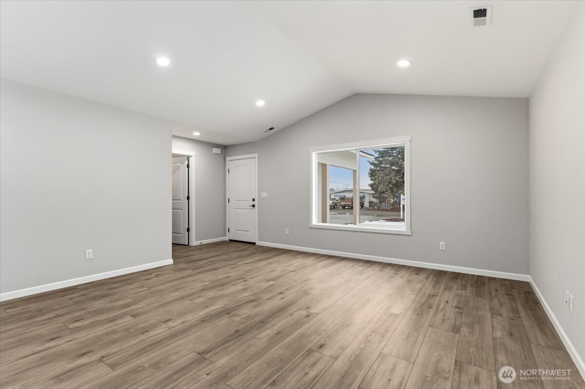 36 Simpson Street Mansfield, WA 98830 - Photo 6 of 28 a view of an empty room with wooden floor and a window