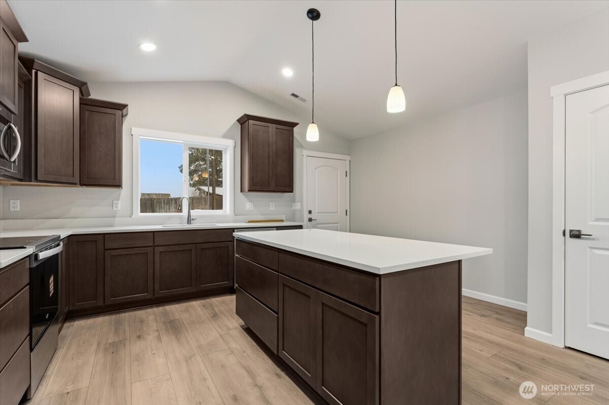 36 Simpson Street Mansfield, WA 98830 - Photo 8 of 28 a kitchen with a sink a center island a stove cabinets and a counter top space