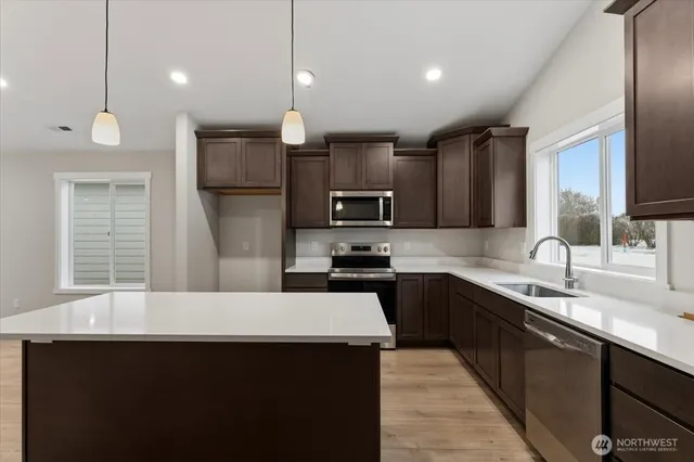 a kitchen with stainless steel appliances a sink stove and cabinets