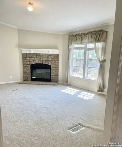 an empty room with a fireplace and windows