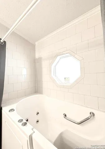 a bathroom with a tub sink and mirror