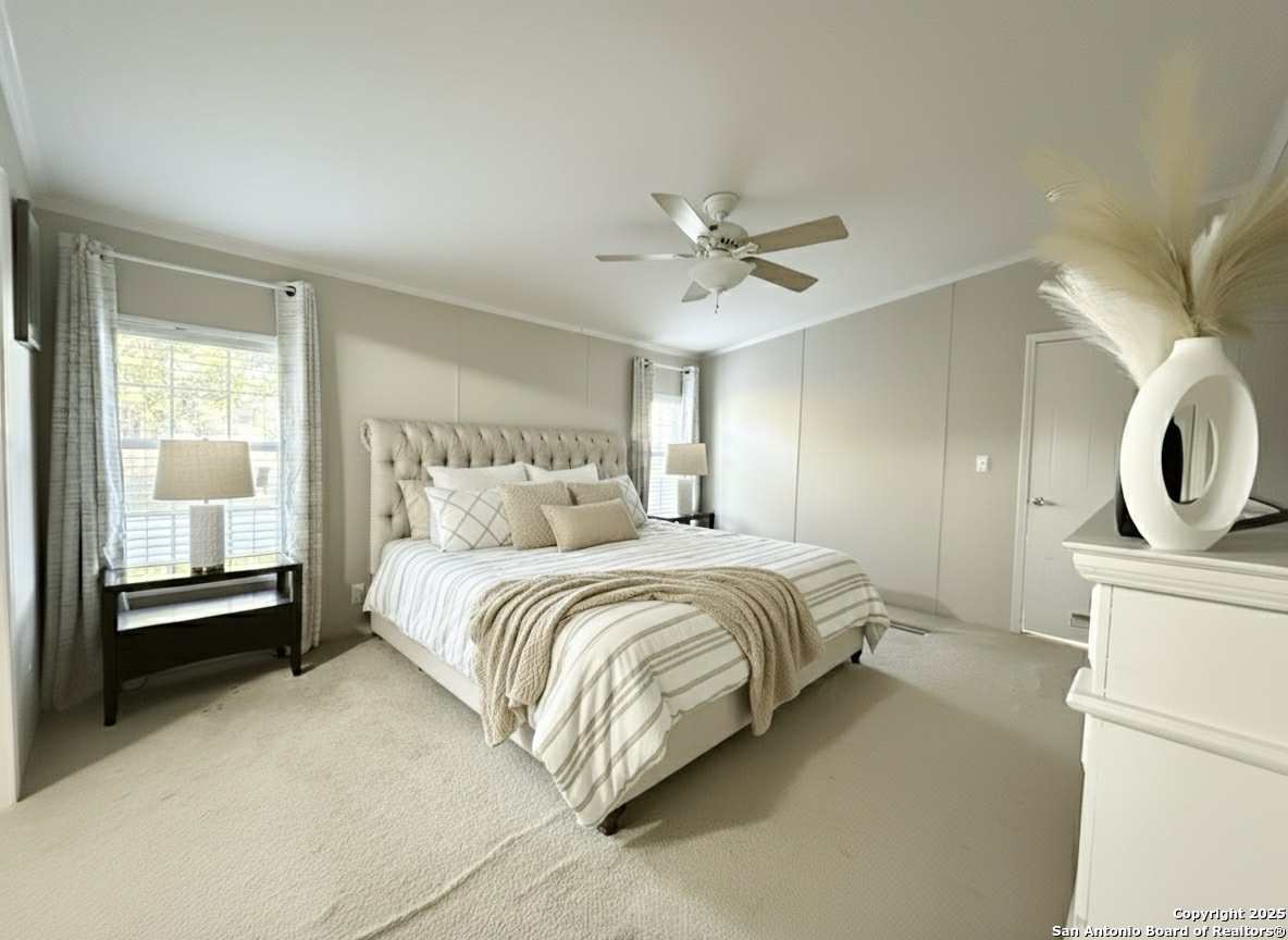 202 South 10th Christine, TX 78012 - Photo 4 of 28 a spacious bedroom with a bed a couch and a window