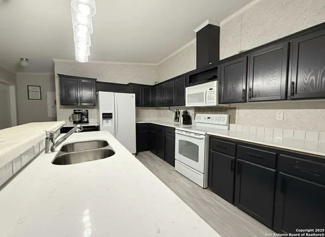 a kitchen with granite countertop a sink and refrigerator