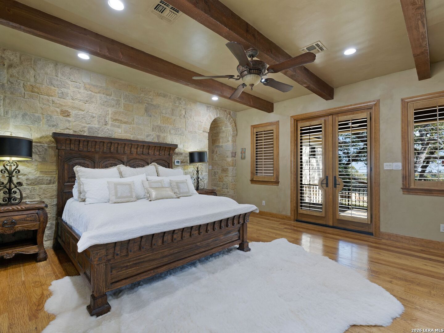 14454 Santa Rita Helotes, TX 78023 - Photo 23 of 70 a spacious bedroom with a bed mirror and a large window