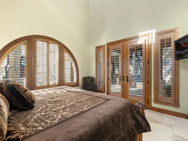 a view of swimming pool with lawn chairs and iron fence