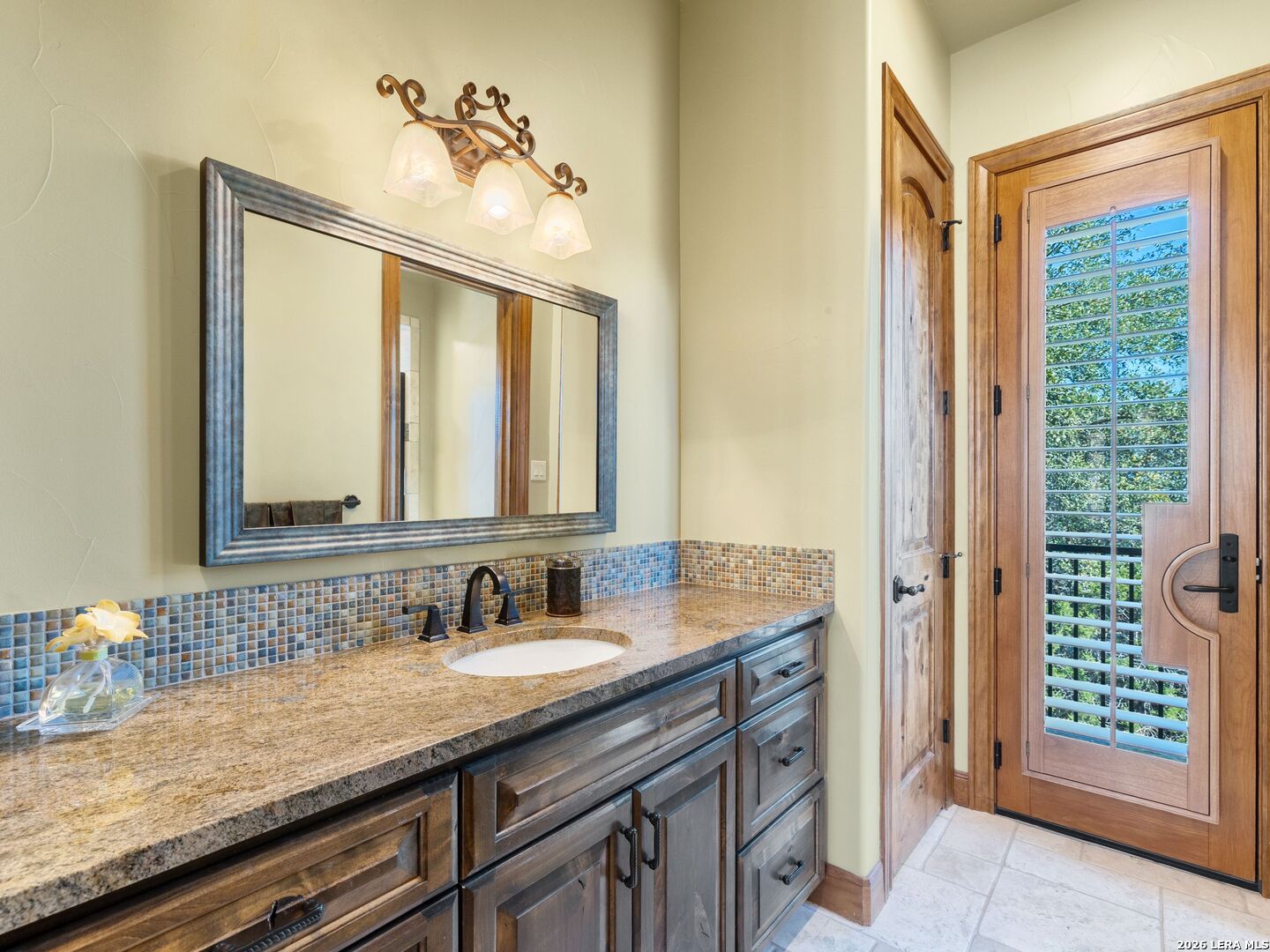 14454 Santa Rita Helotes, TX 78023 - Photo 49 of 70 a bathroom with a granite countertop sink and a mirror
