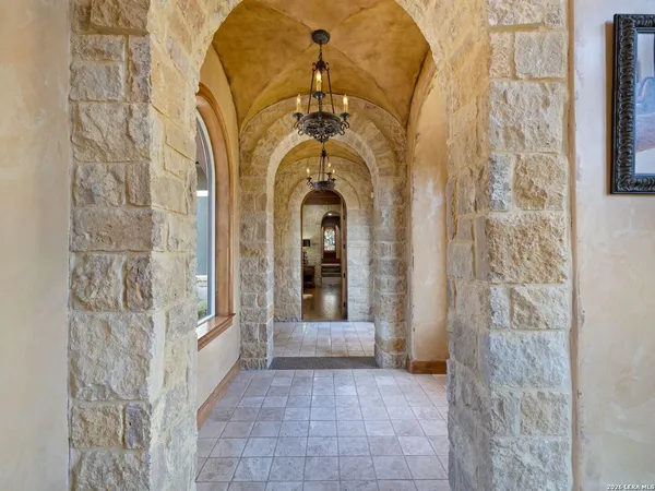 a living room with furniture a chandelier and a fireplace