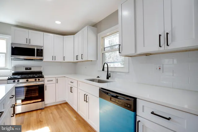 a kitchen with granite countertop a sink a stove and cabinets
