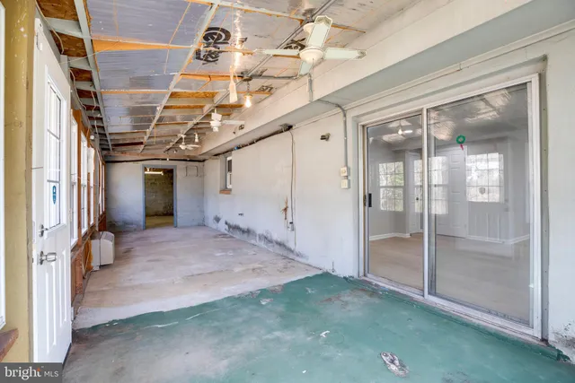a view of a hallway with a glass door and furniture