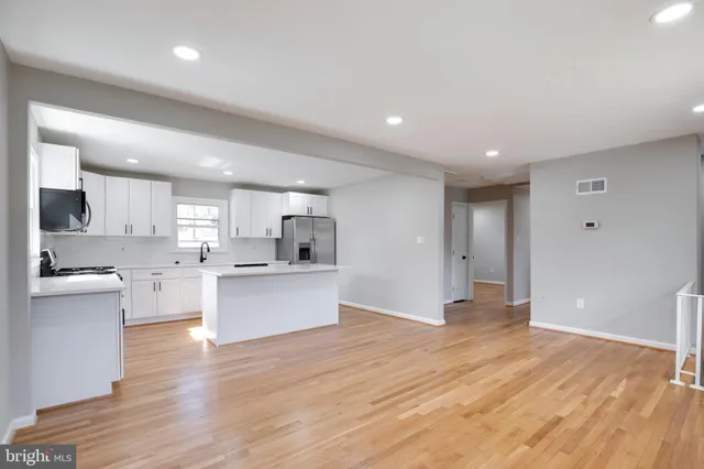 a view of kitchen with wooden floor and stainless steel appliances