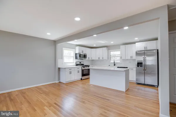 a kitchen with stainless steel appliances kitchen island wooden cabinets and refrigerator