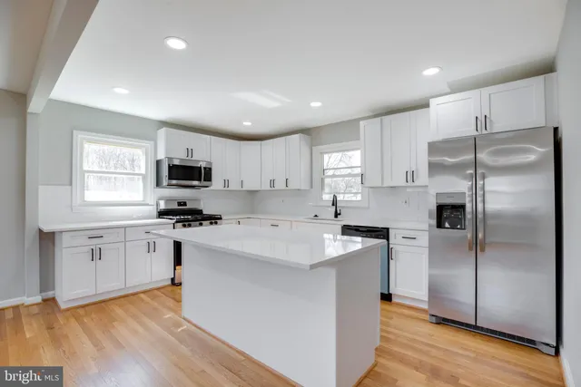 a kitchen with stainless steel appliances a refrigerator sink and microwave