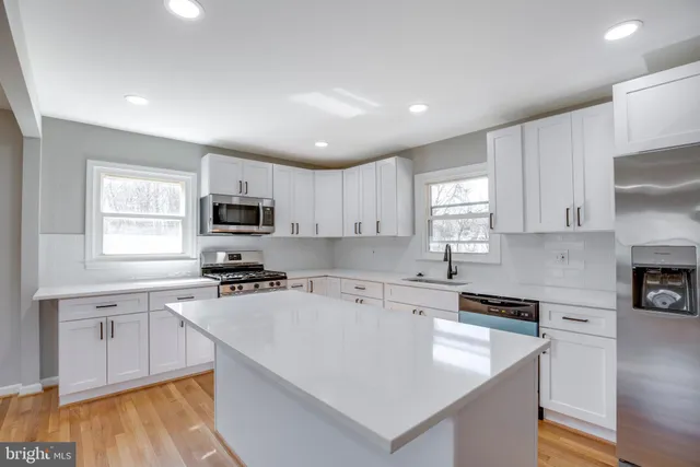 a kitchen with a sink a stove a microwave and cabinets