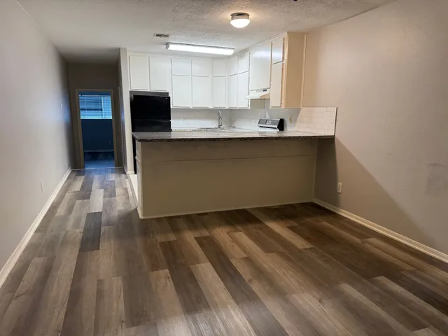 a kitchen with kitchen island granite countertop a sink cabinets and stainless steel appliances